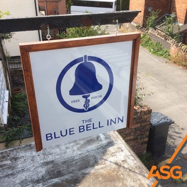 White swing sign with a wooden trim edge for The Blue Bell Inn in Kidsgrove Stoke-on-Trent - Installed and printed by Acres Signs and Graphics
