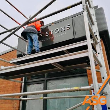 One of the Acres Signs and Graphics team on scaffolding installing some signage for Prestons Coffee Shop, Ashbourne
