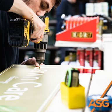 Acres Signs and Graphics team member prepares some interior signage for installation at a garden centre
