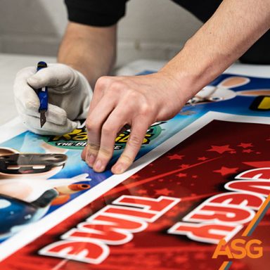 Acres Signs and Graphics team member trims some point of sale signage