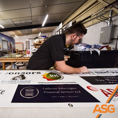 Acres Signs and Graphics team member trims some signage