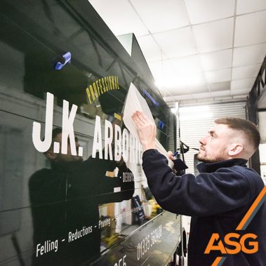 Acres Signs and Graphics team finish off the livery on a black van